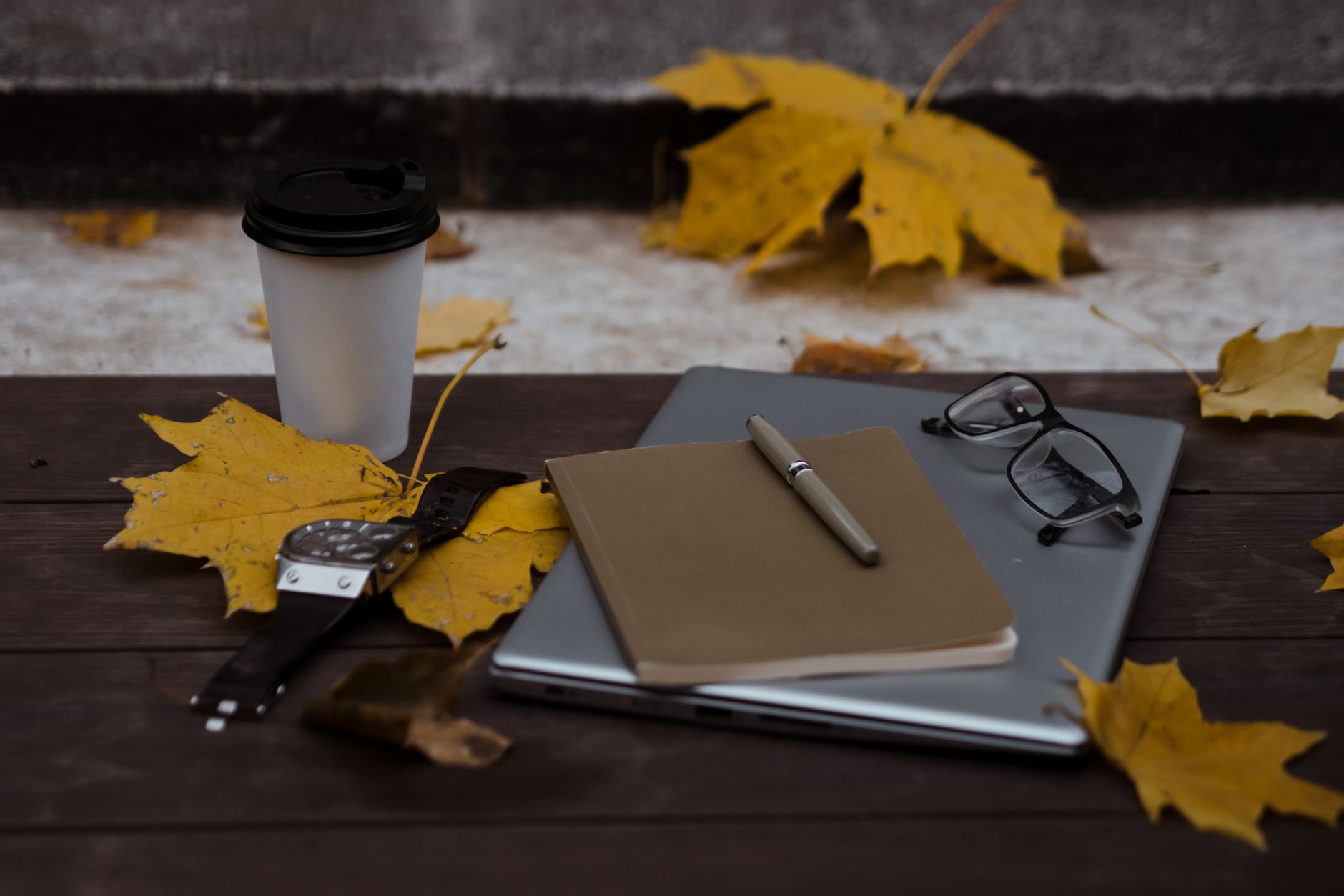 Travel writer taking notes at a rustic wooden cafe table