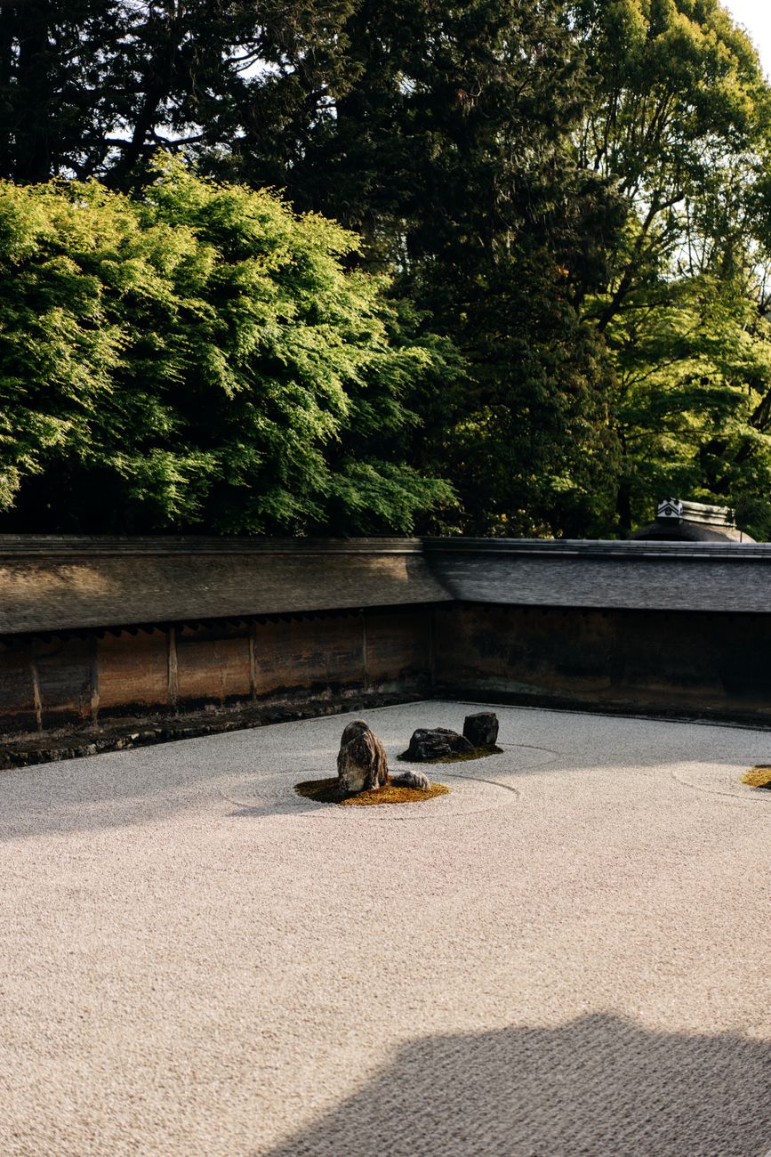 Traditional Japanese Zen Garden with raked white gravel and mossy stones